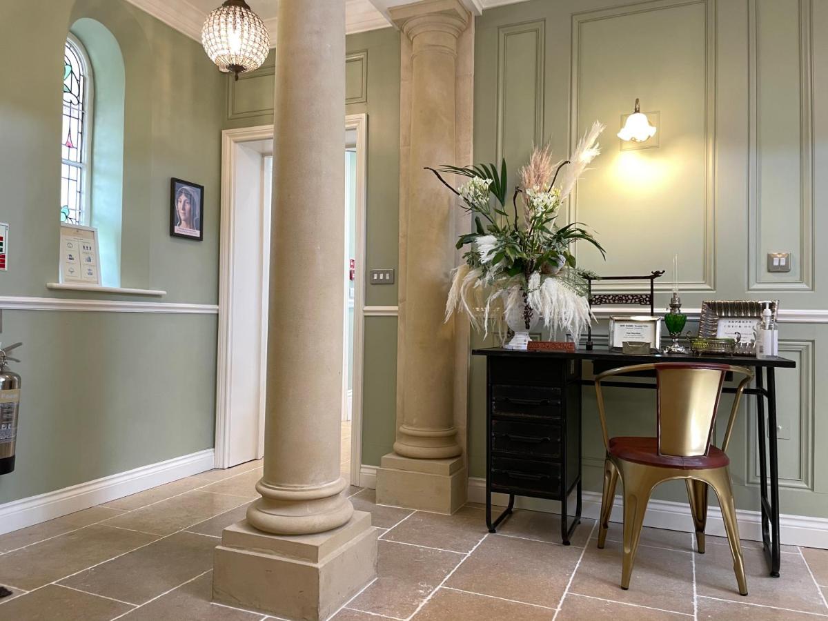 a room with a column and a table with a vase of flowers at Tyndall Villa Boutique B&B in Bath